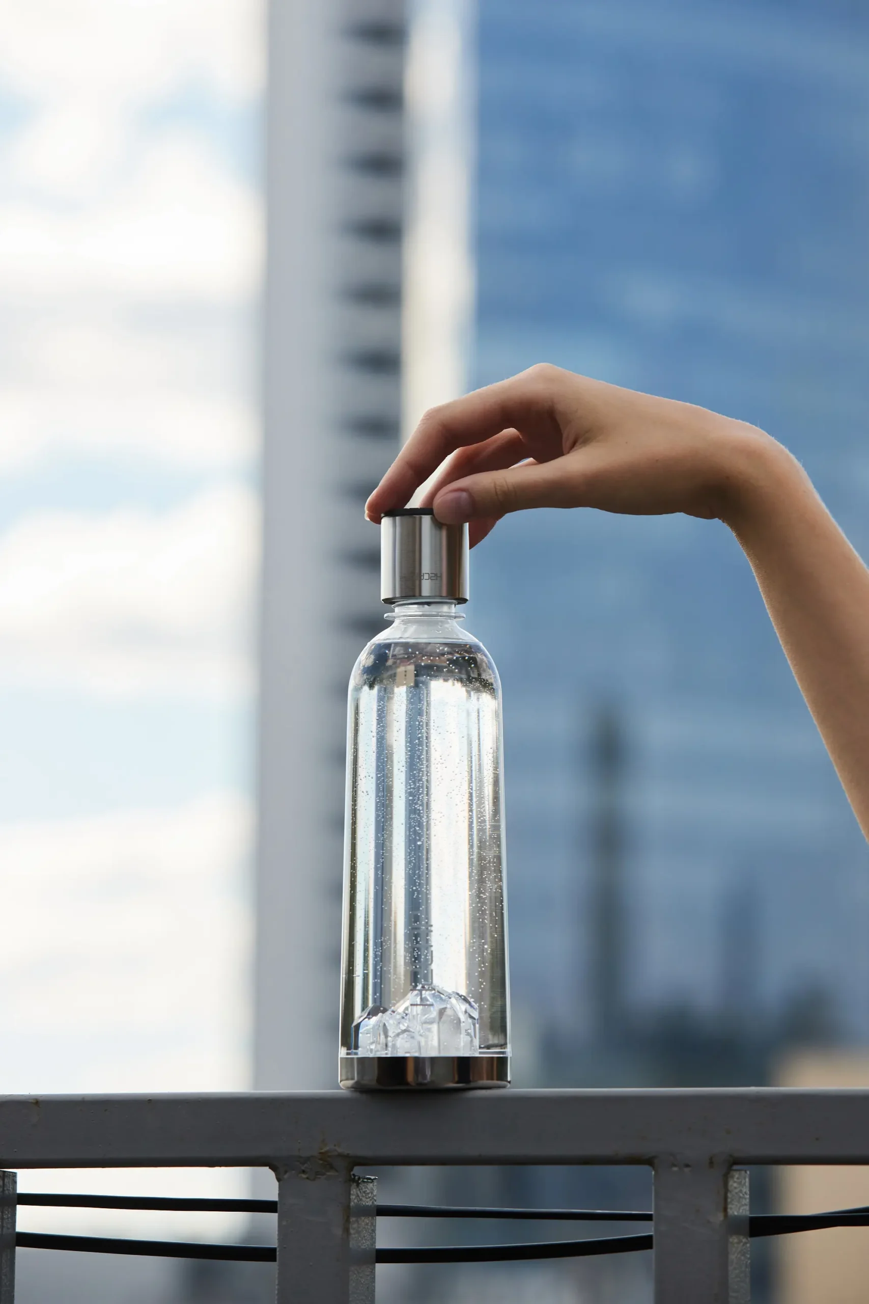 Fitting the H2CAP PLUS cap onto a bottle outdoors